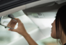 women adjusting car mirror 550x360 at 4 Driving Mistakes Every New Car Owner Must Avoid